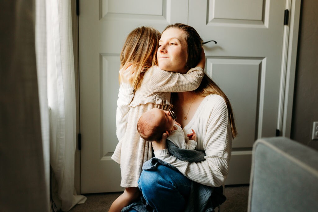 Norman newborn lifestyle photographer captures an image of amother loving on her two littles.