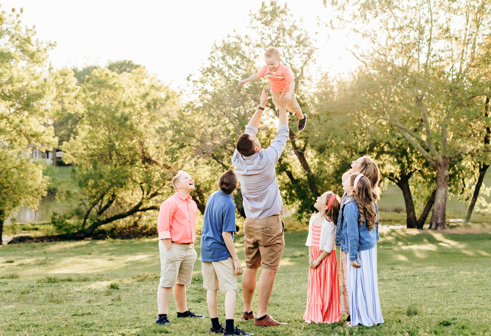 A family of eight plays in a field during their golden hour family session by Charis Elisabeth Photography.