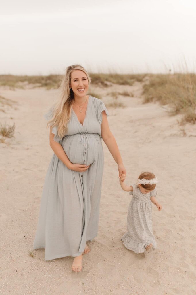OKC doula walks with her daughter on beach.